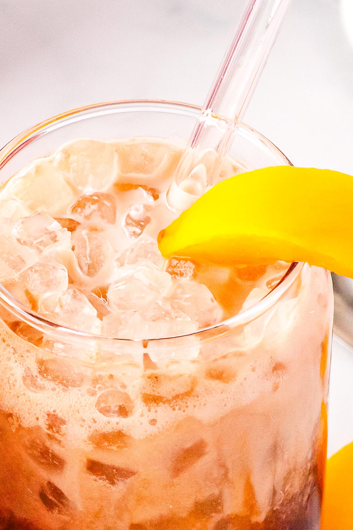 A copycat life's a peach drink with a straw and peach slice in it.