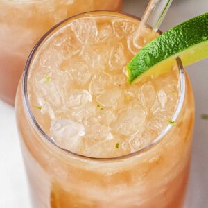 A copycat Swig Fighter refresher drink in a glass with a lime slice in it.