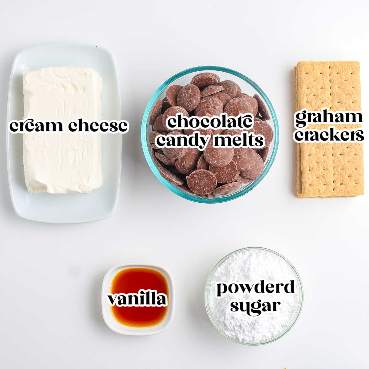 Cream cheese, chocolate candy melts, graham crackers, powdered sugar, and vanilla arranged on a white surface and labeled for cheesecake truffle preparation.