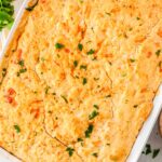 9x13 chicken pot pie with cheddar biscuit topping baked until golden brown and garnished with fresh parsley.