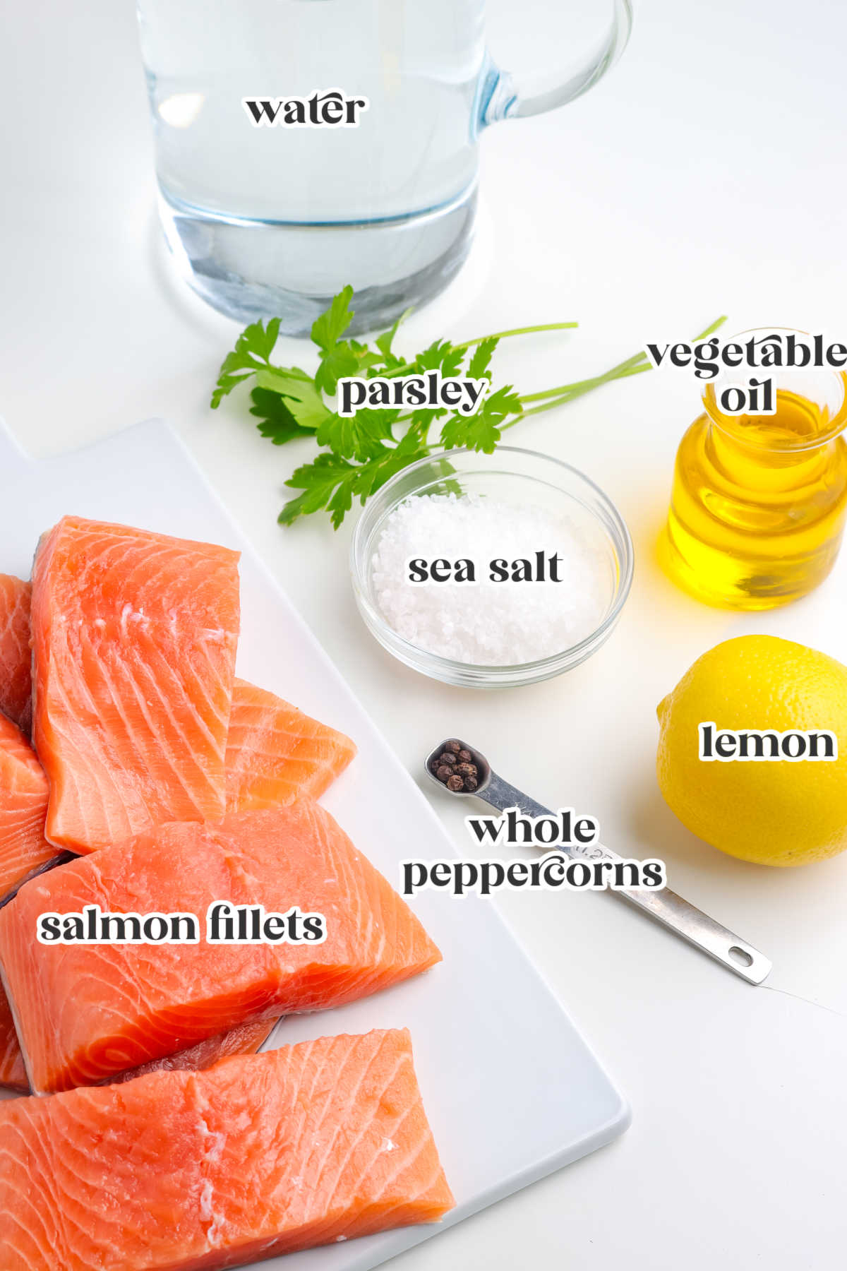 Ingredients for grilled salmon including salmon fillets, sea salt, water, lemon, parsley, peppercorns, and vegetable oil.