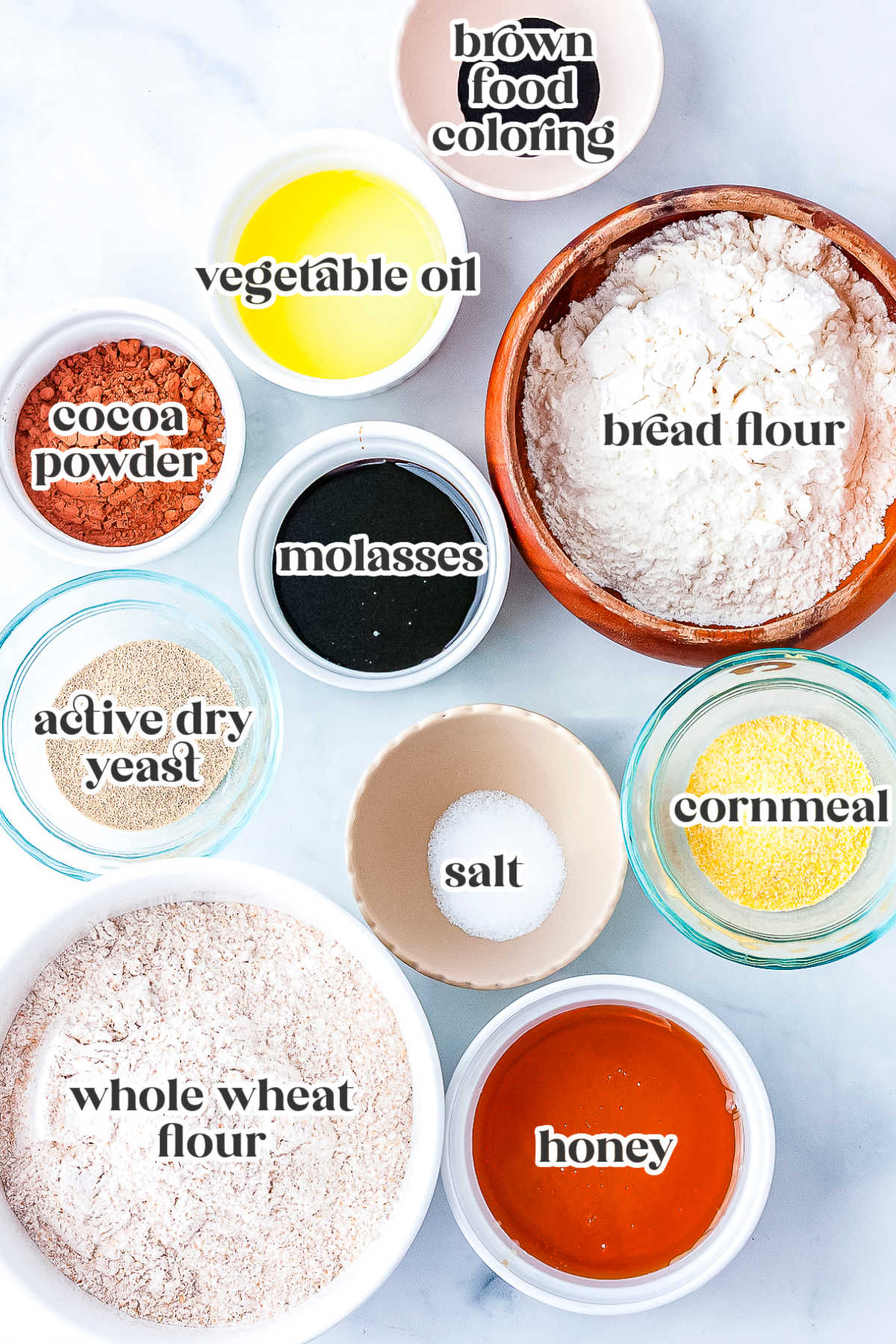 Ingredients for copycat Outback bread including whole wheat flour, bread flour, cocoa powder, honey, molasses, yeast, vegetable oil, and cornmeal.